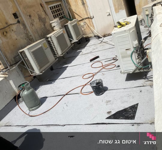 גג עם יריעות איטום, דלי וצינור גז